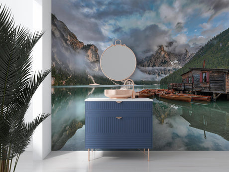 Mountain lake wallpaper creating depth in a modern living room, reflecting natural light with misty peaks and boathouse scene