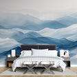 Mountain wall mural in modern living room showing blue abstract waves creating depth against white furniture