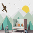 Mountain adventure wallpaper in bright kid's bedroom showing geometric peaks and flying aircraft