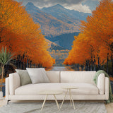 Mountain landscape wallpaper with autumn forest road shown in modern living room, warm orange tones complement contemporary furniture