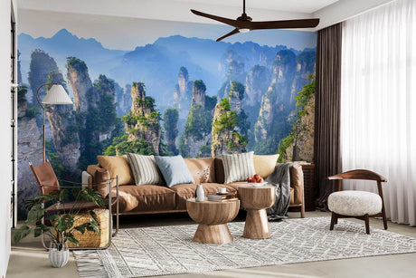 Mountain wallpaper mural creating depth in modern living room with grey sofa and natural light