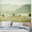 Mountain landscape wallpaper creating depth in a modern living room with grey sofa and natural light