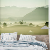Mountain landscape wallpaper creating depth in a modern living room with grey sofa and natural light