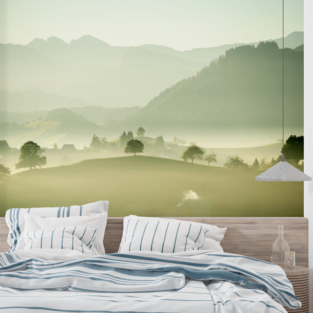 Mountain landscape wallpaper creating depth in a modern living room with grey sofa and natural light