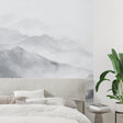 Mountain landscape wallpaper creating depth in modern living room with grey sofa and minimal decor
