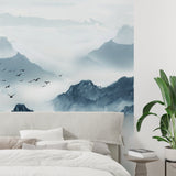 Mountain landscape wallpaper in minimal bedroom with white bedding and wooden furniture