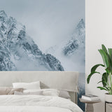 Misty mountain mural in minimalist bedroom setting with white bedding