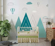 Mountain nursery wallpaper with hot air balloons shown in a bright modern nursery with white furniture