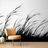 Black and white grass silhouette wallpaper creating movement in a modern minimalist living room with natural light