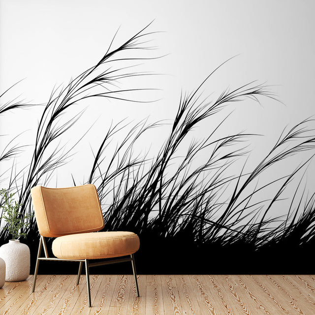 Black and white grass silhouette wallpaper creating movement in a modern minimalist living room with natural light