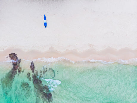 Aerial beach design file showing turquoise waters meeting sandy shores with surfboard accent