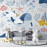 Ocean themed nursery wall mural creating calm atmosphere with swimming whales