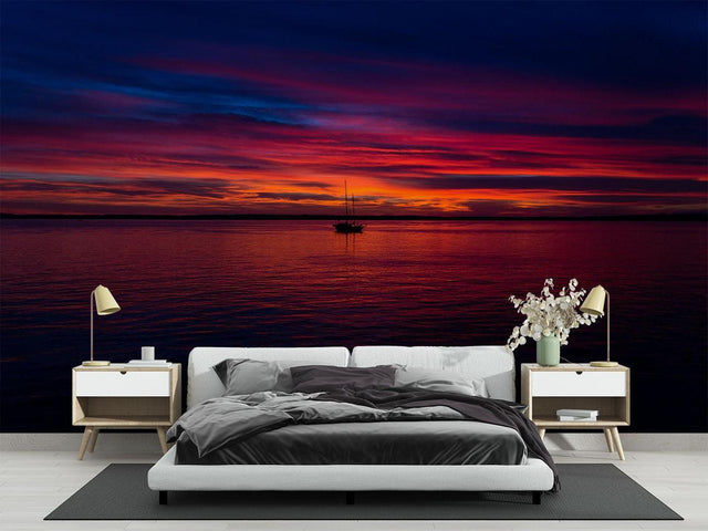 Ocean sunset mural wallpaper creating a cozy atmosphere in a modern living room with floor-to-ceiling windows
