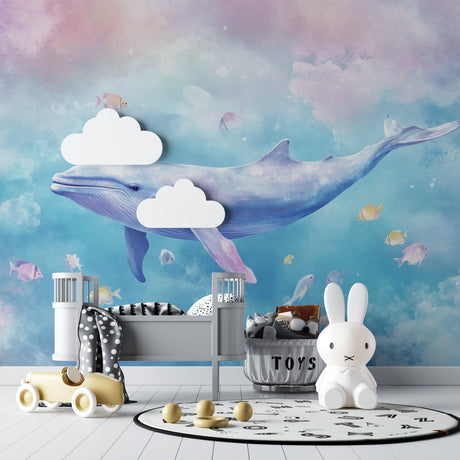 Ocean Mural Wallpaper with dreamy whale design shown in a bright nursery with white furniture
