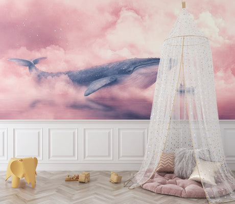 Pink whale wallpaper creating a dreamy atmosphere in a modern nursery with white furniture