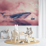 Whale wall mural in pink clouds displayed in playroom setting