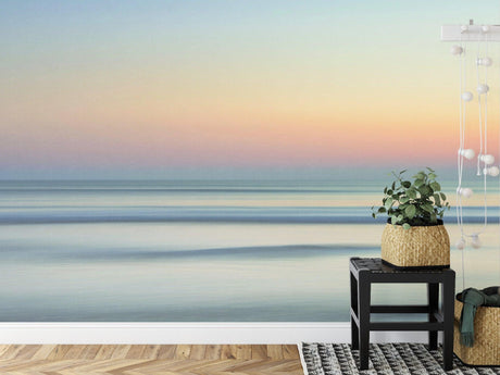 Ocean sunset wallpaper creating a calm atmosphere in a modern living room with minimal furniture