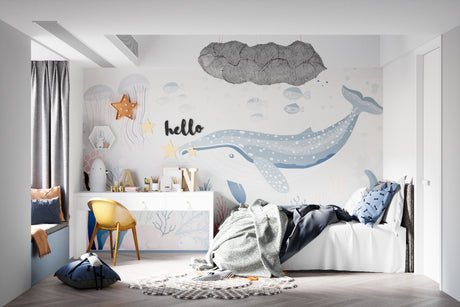 Ocean theme wallpaper with whale design shown in a bright nursery with white furniture