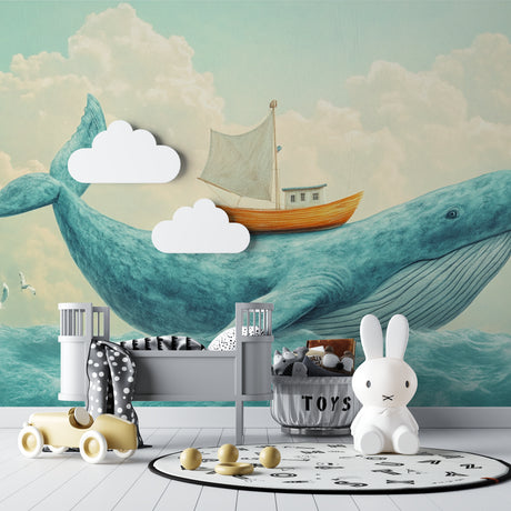 Ocean whale wallpaper mural in a bright nursery with white furniture and soft textiles
