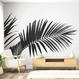 Black and white palm leaf mural wallpaper creating a bold statement in a bright modern living room with minimal furniture