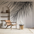 Black and white palm leaf mural wallpaper creating dramatic focal point in modern minimalist living room