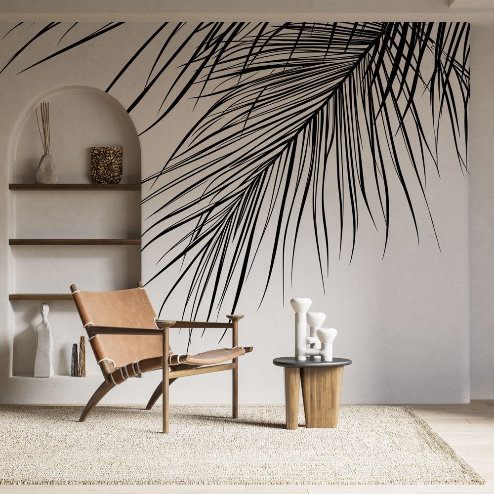 Black and white palm leaf mural wallpaper creating dramatic focal point in modern minimalist living room
