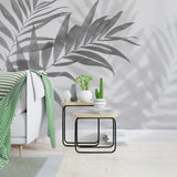 Botanical wall mural with palm shadows adding depth to a contemporary bedroom space