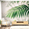 Tropical palm leaf wallpaper creating a fresh focal point in a modern living room with white furniture and natural light