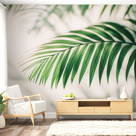 Tropical palm leaf wallpaper creating a fresh focal point in a modern living room with white furniture and natural light