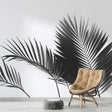 Black and white palm leaf wallpaper creating drama in a modern living room with clean furniture and natural light