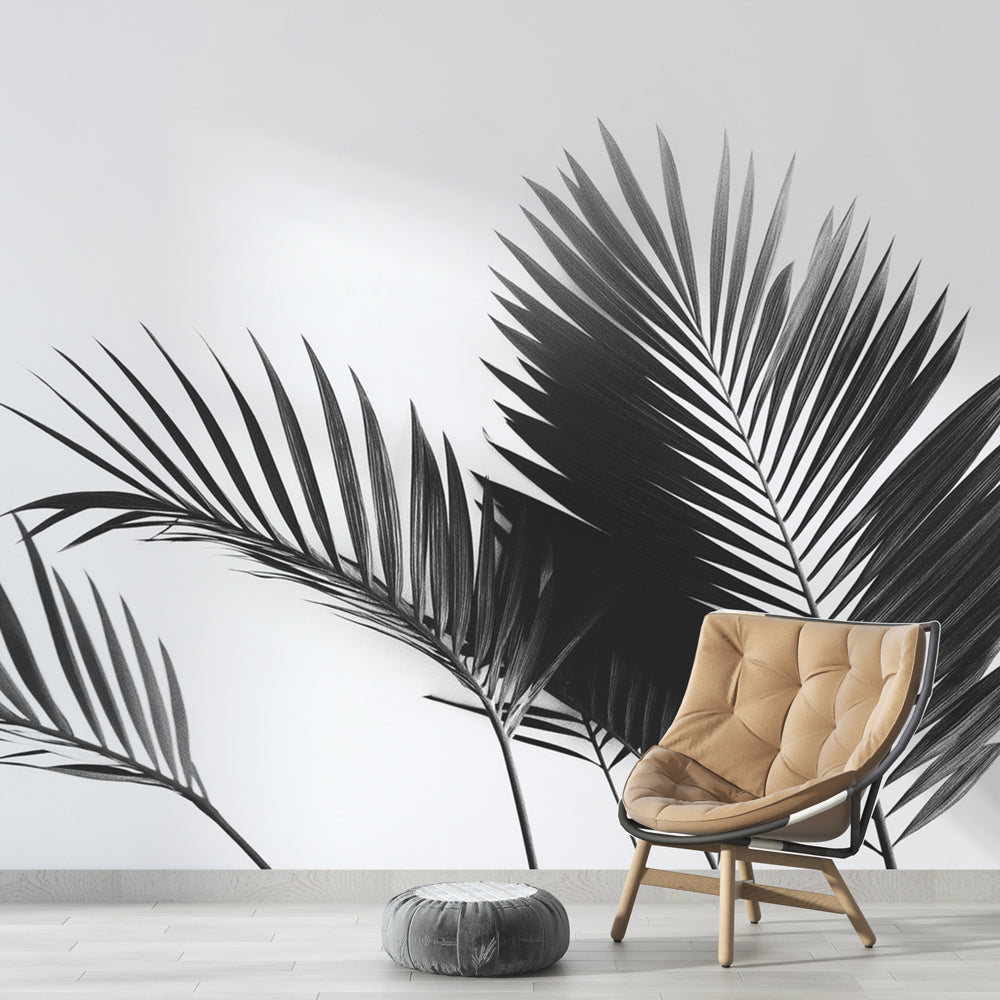 Black and white palm leaf wallpaper creating drama in a modern living room with clean furniture and natural light