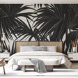 Black and white palm leaves wallpaper creating dramatic contrast in a modern living room with minimal furniture