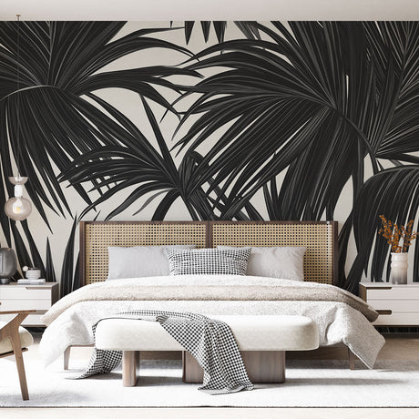 Black and white palm leaves wallpaper creating dramatic contrast in a modern living room with minimal furniture