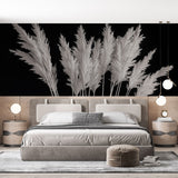 Black and white pampas grass wallpaper creating a bold statement wall in a minimalist living room with natural light