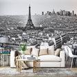Black and white Paris cityscape wallpaper creating depth in modern living room with gray sofa and minimal decor