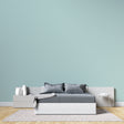 Modern mint green wallpaper in bright living room with natural light and minimal furniture