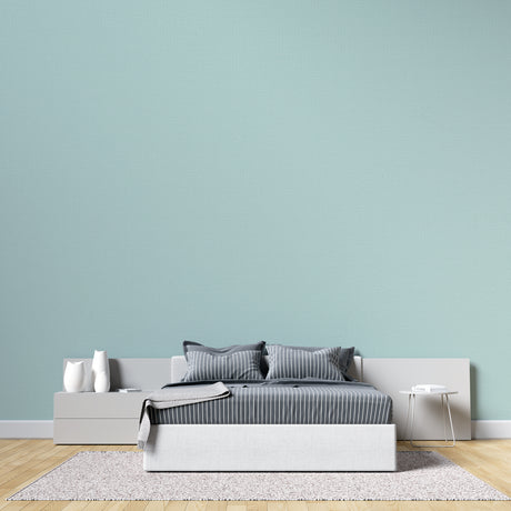 Modern mint green wallpaper in bright living room with natural light and minimal furniture