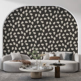 Modern abstract pattern wallpaper with white drops shown in a minimalist living room, creating dramatic contrast against furniture