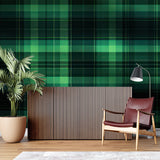 Home office featuring green tartan wallpaper with wooden desk and leather chair