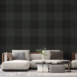 Green Buffalo Check Wallpaper creating a cozy atmosphere in a modern living room with leather furniture and natural light