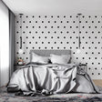 Modern black and white polka dot wallpaper in a minimalist living room setting