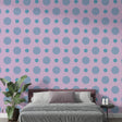 Pink and blue polka dot wallpaper creating a cheerful atmosphere in a modern nursery with white furniture