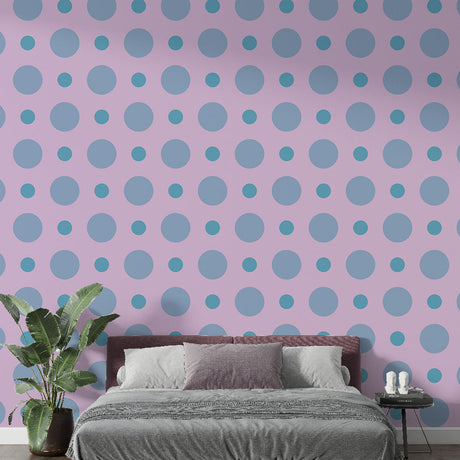 Pink and blue polka dot wallpaper creating a cheerful atmosphere in a modern nursery with white furniture