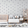 Silver polka dot wallpaper creating a magical atmosphere in a modern nursery with soft lighting