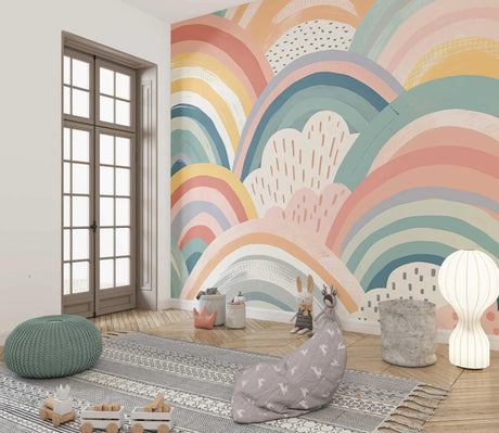 Rainbow pastel wallpaper mural creating a soft, dreamy atmosphere in a modern nursery with white furniture