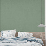 Minimalist sage green wall mural creating calm atmosphere in bedroom setting