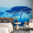 Blue African savanna wallpaper creates a serene atmosphere in a modern living room with minimal furniture