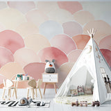 Pink watercolor scallop mural in a reading nook with cozy seating