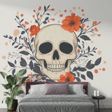 Gothic skull wallpaper with orange flowers creating dramatic impact in modern living room with grey sofa and minimal decor