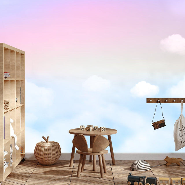 Pink and blue cloud mural wallpaper creating a peaceful atmosphere in a modern nursery with white furniture